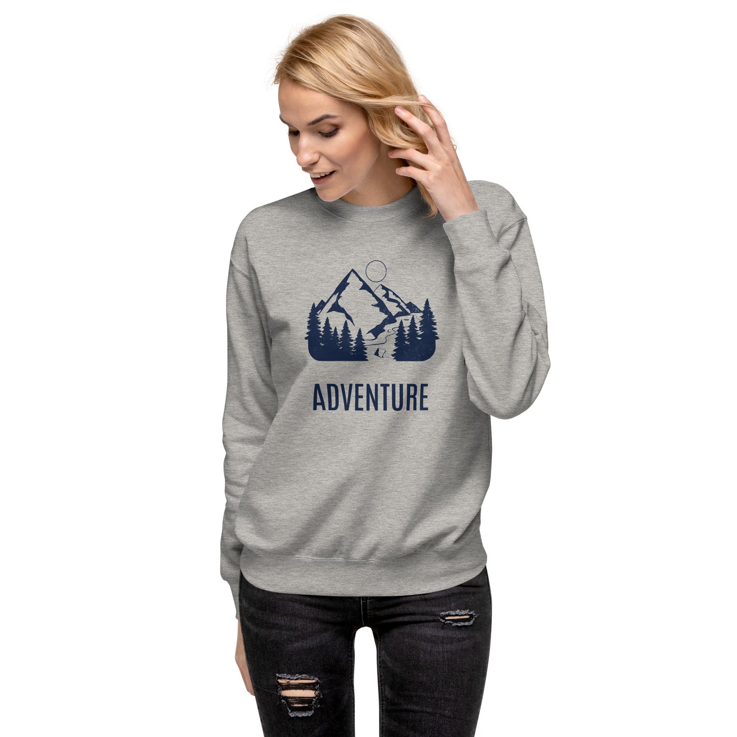 Woman wearing a gray sweatshirt with a mountain and tree design and the word 'ADVENTURE'.